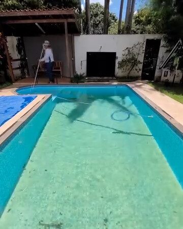 A mesma piscina com água esverdeada antes do tratamento